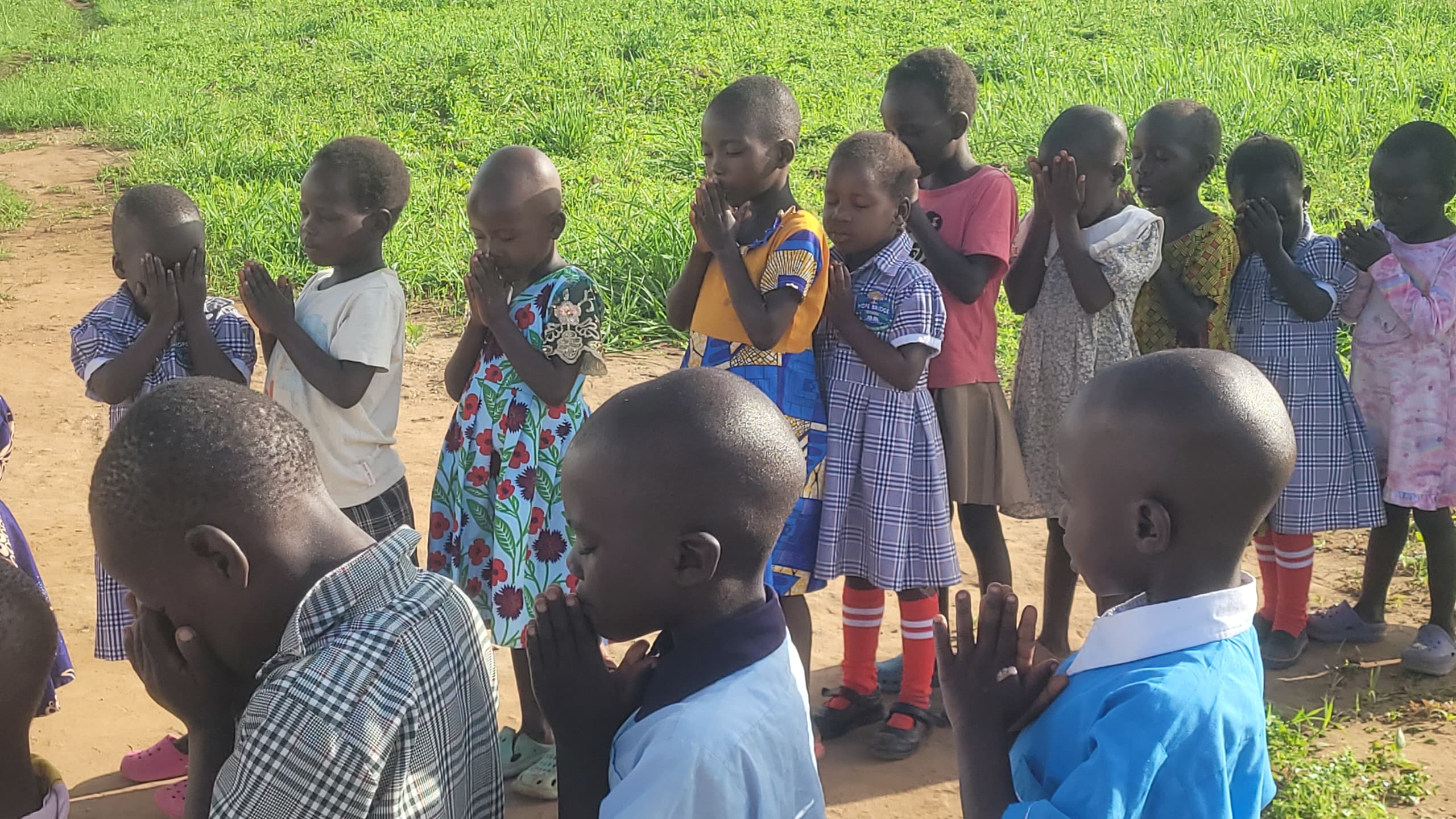 Nursery kids at morning devotions, hands pressed together