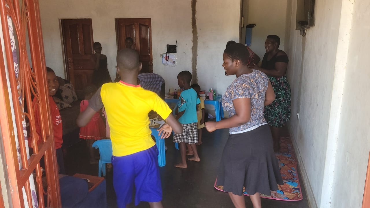 Kids and staff dancing in a room at the campus